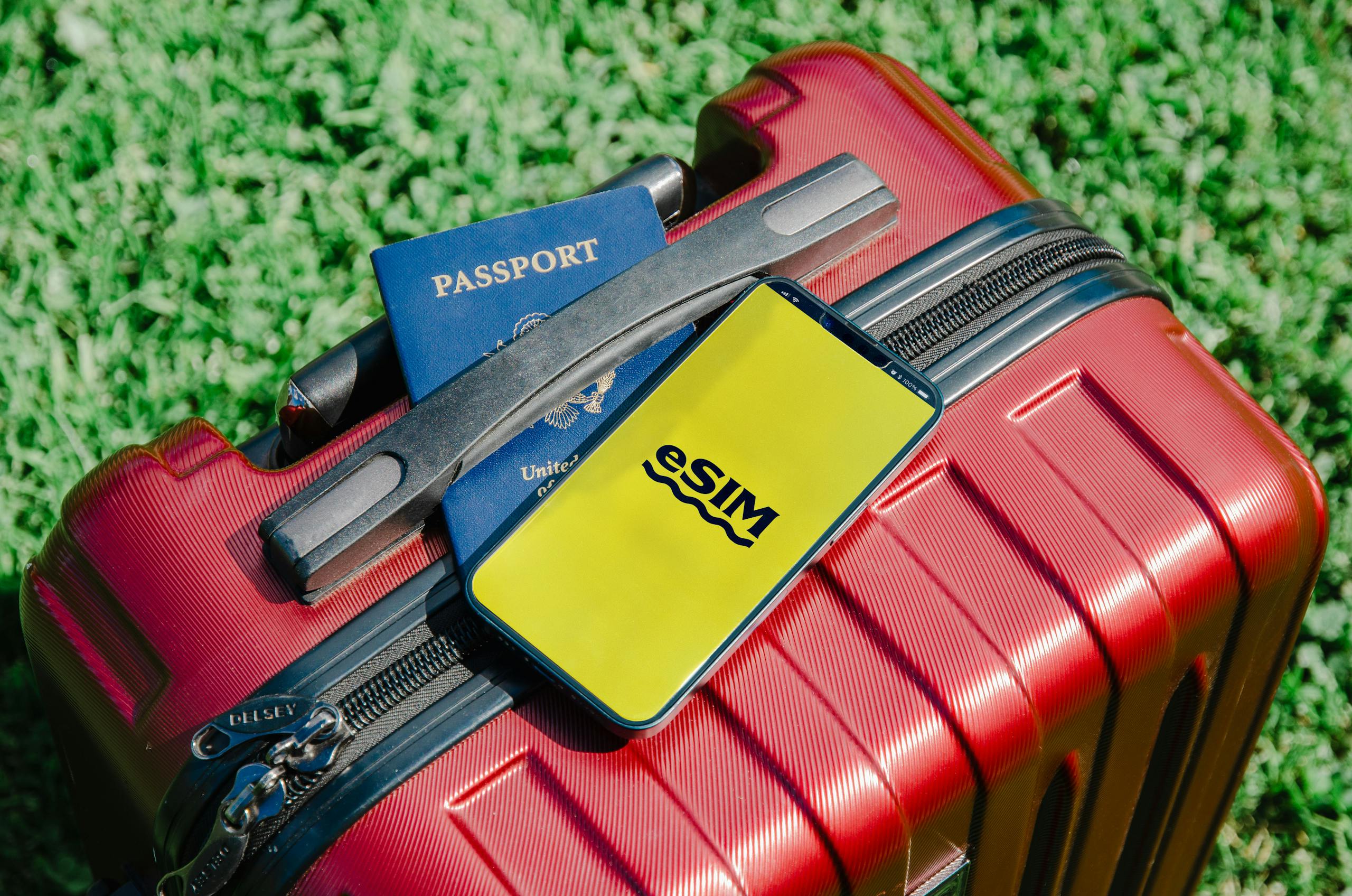 Smartphone con eSIM, passaporto e valigia rossa pronti per un viaggio in Russia