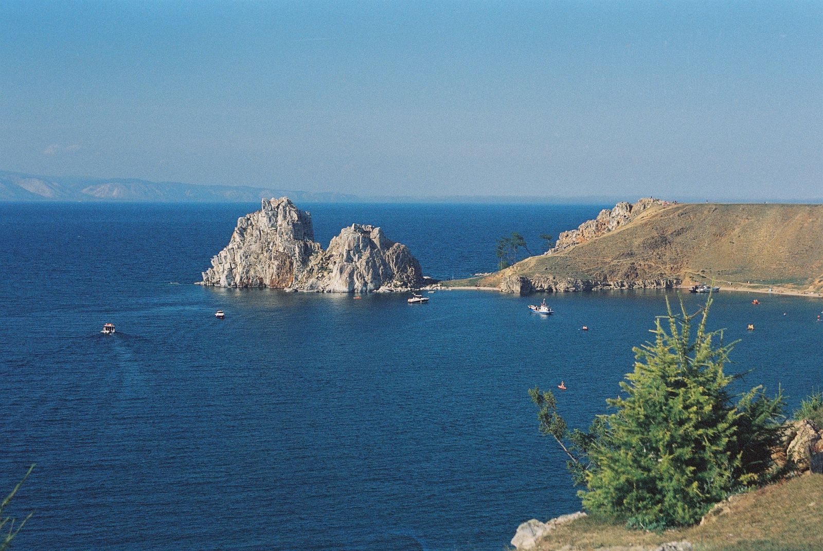 La Roccia dello Sciamano sull'isola di Olkhon, nel lago Bajkal, con le acque blu e la costa rocciosa